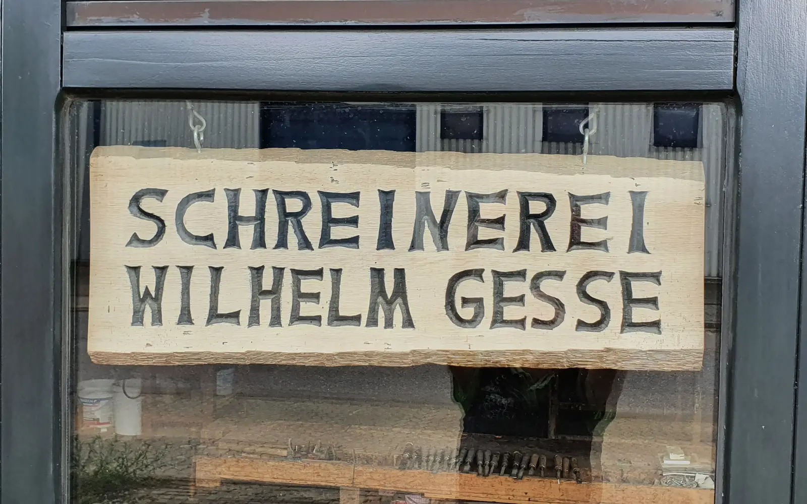 Eingang mit Hinweis auf die Schreinerei Fenster Schreinerwerkstatt, Holzschild mit Beschriftung "Schreinerei Wilhelm Gesse"